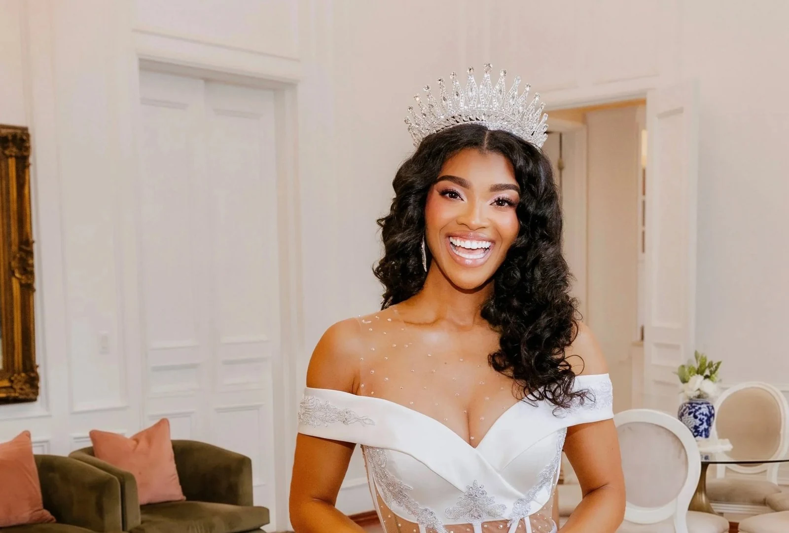 Smiling bride with soft pink makeup, flowing curls and a jeweled crown